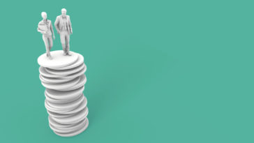 two people standing on top of a stack of coins