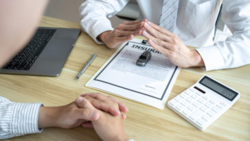 insurance papers with a car and a calculator