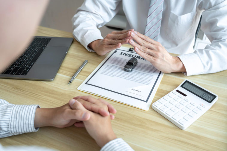 insurance papers with a car and a calculator