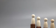 miniature people standing on coin stacks