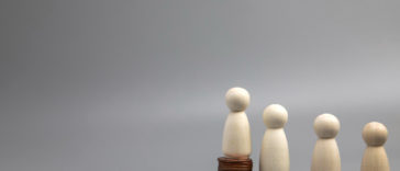 miniature people standing on coin stacks