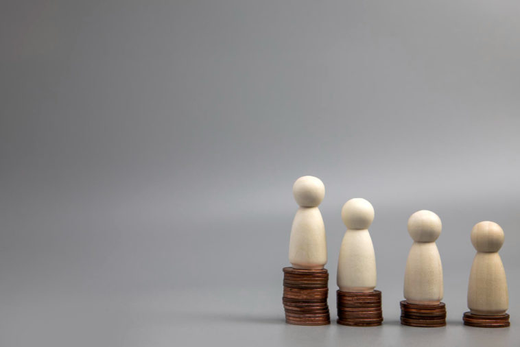 miniature people standing on coin stacks