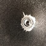 bullet stuck in metal sheet