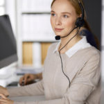woman at a computer talking on a headset