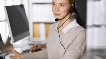 woman at a computer talking on a headset