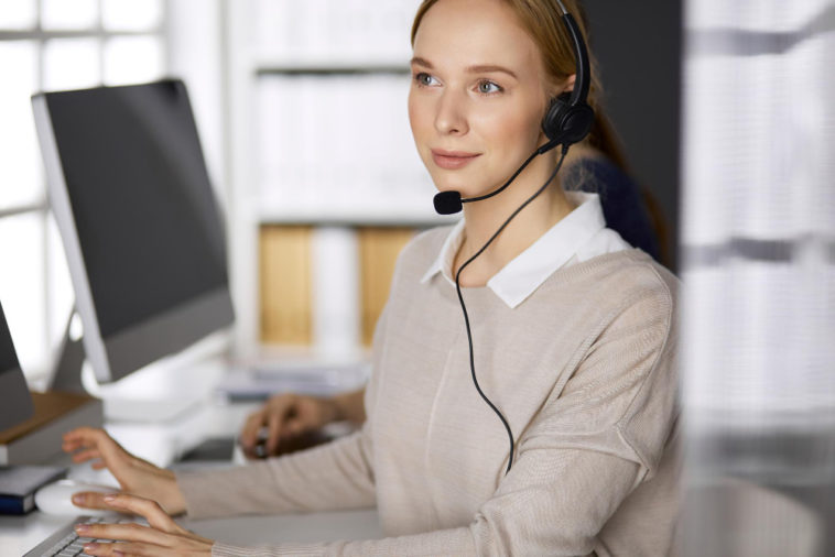 woman at a computer talking on a headset