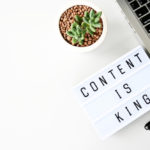 content is king sing next to a laptop and a pen