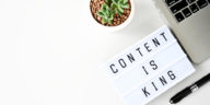 content is king sing next to a laptop and a pen