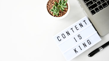 content is king sing next to a laptop and a pen