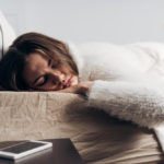 woman sleeping with a phone next to her bed