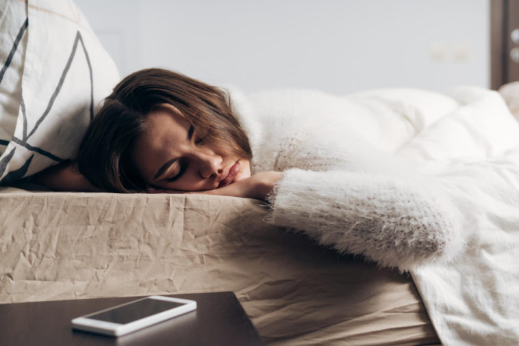 woman sleeping with a phone next to her bed