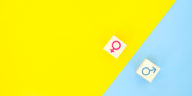 female and male gender symbols on top of yellow and blue background
