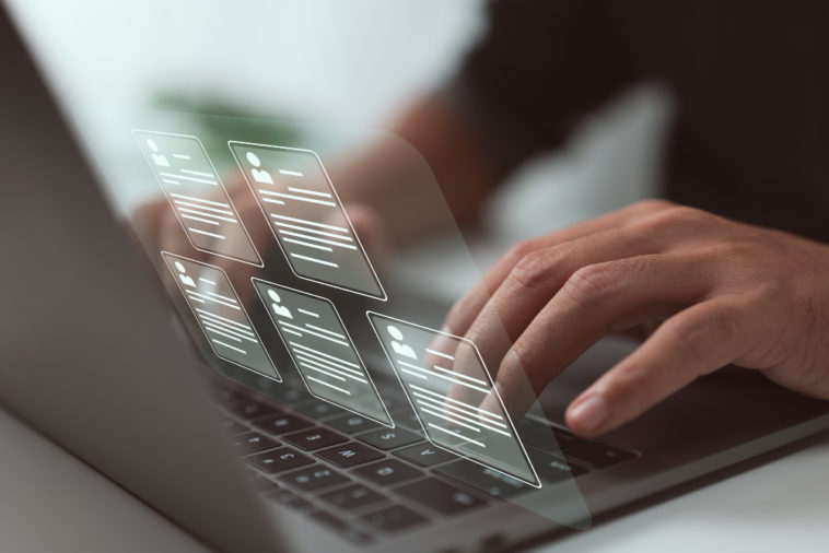 person typing looking at resumes on a virtual screen