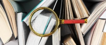 magnifying glass on top of books