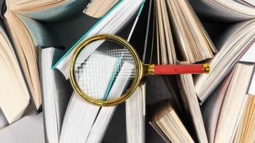 magnifying glass on top of books