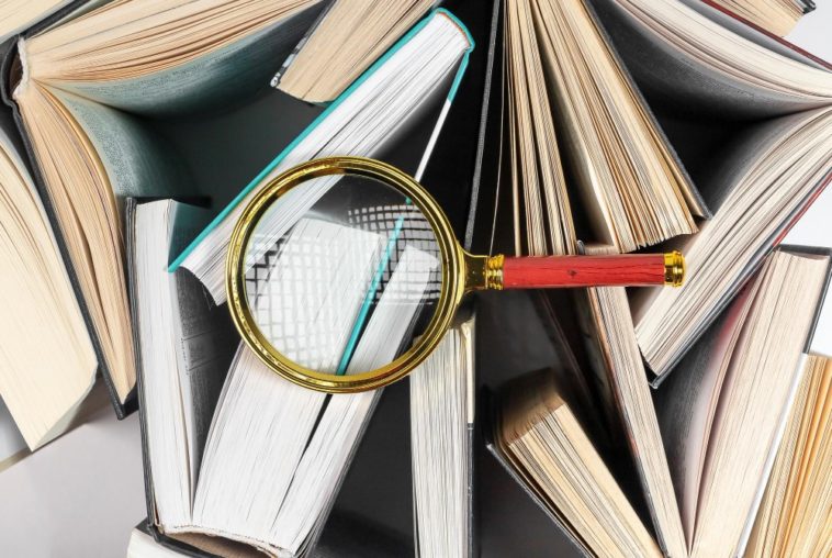 magnifying glass on top of books