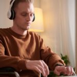 man typing with a headset on his head