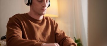 man typing with a headset on his head