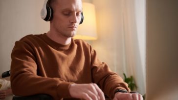 man typing with a headset on his head