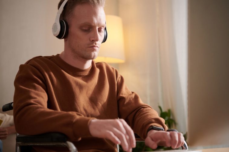 man typing with a headset on his head