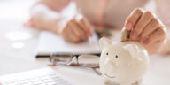 woman putting money into piggy bank