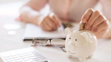 woman putting money into piggy bank