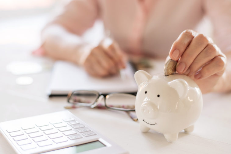 woman putting money into piggy bank