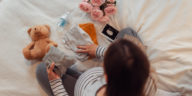 pregnant woman folding baby clothes