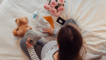 pregnant woman folding baby clothes