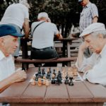 senior men playing chess in park