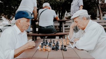 senior men playing chess in park