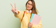 student smiling and gesturing the peace sign