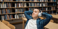 student listening to an audiobook in a library