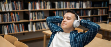 student listening to an audiobook in a library