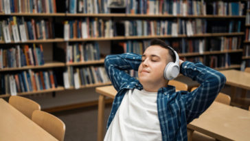 student listening to an audiobook in a library