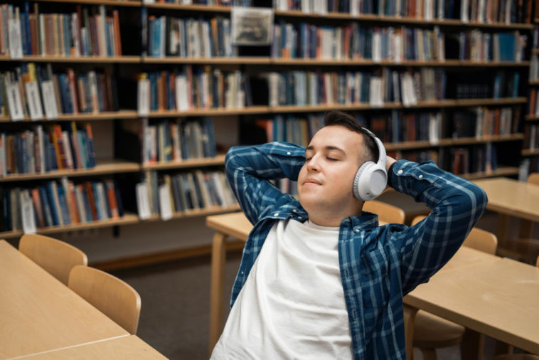 student listening to an audiobook in a library