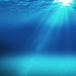blue underwater space with light going through the surface