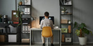 back view of a man using a computer in a home office