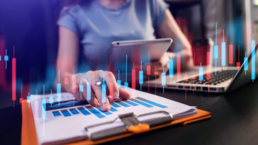 woman working in a modern office with a graph indicator