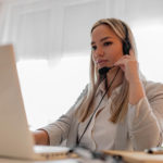 woman sitting in front of a laptop with headphones