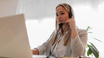 woman sitting in front of a laptop with headphones