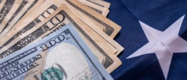 dollar bills stacked on us falg