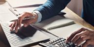 businessman working at a desk using a calculator