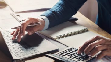 businessman working at a desk using a calculator