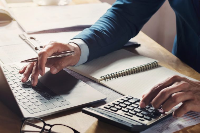 businessman working at a desk using a calculator