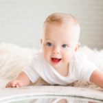 cute happy baby with an all white surrounding