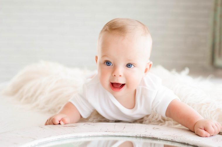 cute happy baby with an all white surrounding