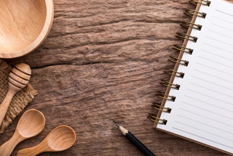 wooden table with wooden utensils and a notebook on it