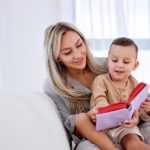 woman holding a child and reading a book