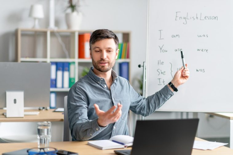 man giving remote English language lessons via a laptop